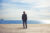 Business man standing on a pier looks the sea